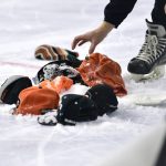 
              Ice crews clean hats off the ice, that were tossed by fans, after Philadelphia Flyers' Cam Atkinson scored his third goal during the third period of an NHL hockey game against the New Jersey Devils, Tuesday, Dec. 14, 2021, in Philadelphia. (AP Photo/Derik Hamilton)
            
