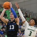 
              BYU guard Alex Barcello (13) shoots as Utah Valley guard Blaze Nield (3) defends in the first half during an NCAA college basketball game Wednesday, Dec. 1, 2021, in Orem, Utah. (AP Photo/Rick Bowmer)
            
