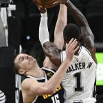 
              Denver Nuggets' Nikola Jokic (15) collides with San Antonio Spurs' Lonnie Walker IV during the first half of an NBA basketball game Thursday, Dec. 9, 2021, in San Antonio. (AP Photo/Darren Abate)
            