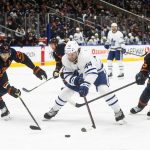 
              Toronto Maple Leafs' Morgan Rielly (44) is chased by Edmonton Oilers' Darnell Nurse (25) and Evan Bouchard (75) during the first period of an NHL hockey game Tuesday, Dec. 14, 2021 in Edmonton, Alberta  (Jason Franson/The Canadian Press via AP)
            