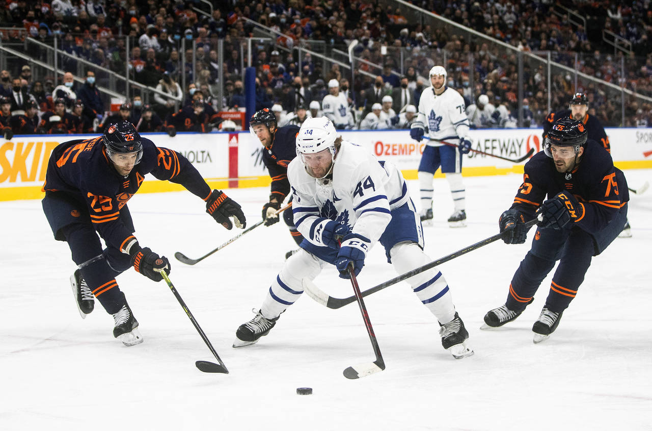 Toronto Maple Leafs' Morgan Rielly (44) is chased by Edmonton Oilers' Darnell Nurse (25) and Evan B...