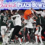 
              The Michigan State team celebrates a victory over Pittsburgh after the Peach Bowl NCAA college football game, Thursday, Dec. 30, 2021, in Atlanta. Michigan State won 31-21.(AP Photo/John Bazemore)
            