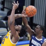 
              Pittsburgh forward John Hugley, left, is fouled by Monmouth forward Nikkei Rutty (21) during the first half of an NCAA college basketball game in Pittsburgh, Sunday, Dec. 12, 2021. (AP Photo/Gene J. Puskar)
            