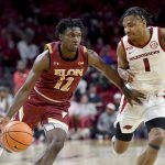 
              Elon guard Darius Burford (12) tries to get past Arkansas guard JD Notae (1) during the second half of an NCAA college basketball game Tuesday, Dec. 21, 2021, in Fayetteville, Ark. (AP Photo/Michael Woods)
            