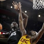 
              Long Beach State forward Aboubacar Traore, left, shoots against Southern California forward Chevez Goodwin, but is called for an offensive foul during the second half of an NCAA college basketball game in Los Angeles, Sunday, Dec. 12, 2021. (AP Photo/Alex Gallardo)
            