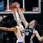 
              San Antonio Spurs center Jakob Poeltl (25) fouls Phoenix Suns guard Landry Shamet (14) as Shamet misses a dunk during the first half of an NBA basketball game Monday, Dec. 6, 2021, in Phoenix. (AP Photo/Ross D. Franklin)
            