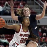 
              North Carolina State forward Kayla Jones (25) dribbles against Saint Mary's forward Ali Bamberger during the first half of an NCAA college basketball game in Raleigh, N.C., Sunday, Dec. 12, 2021. (AP Photo/Gerry Broome)
            