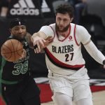 
              Boston Celtics guard Marcus Smart, left, and Portland Trail Blazers center Jusuf Nurkic, right, battle for a loose ball during the first half of an NBA basketball game in Portland, Ore., Saturday, Dec. 4, 2021. (AP Photo/Steve Dipaola)
            
