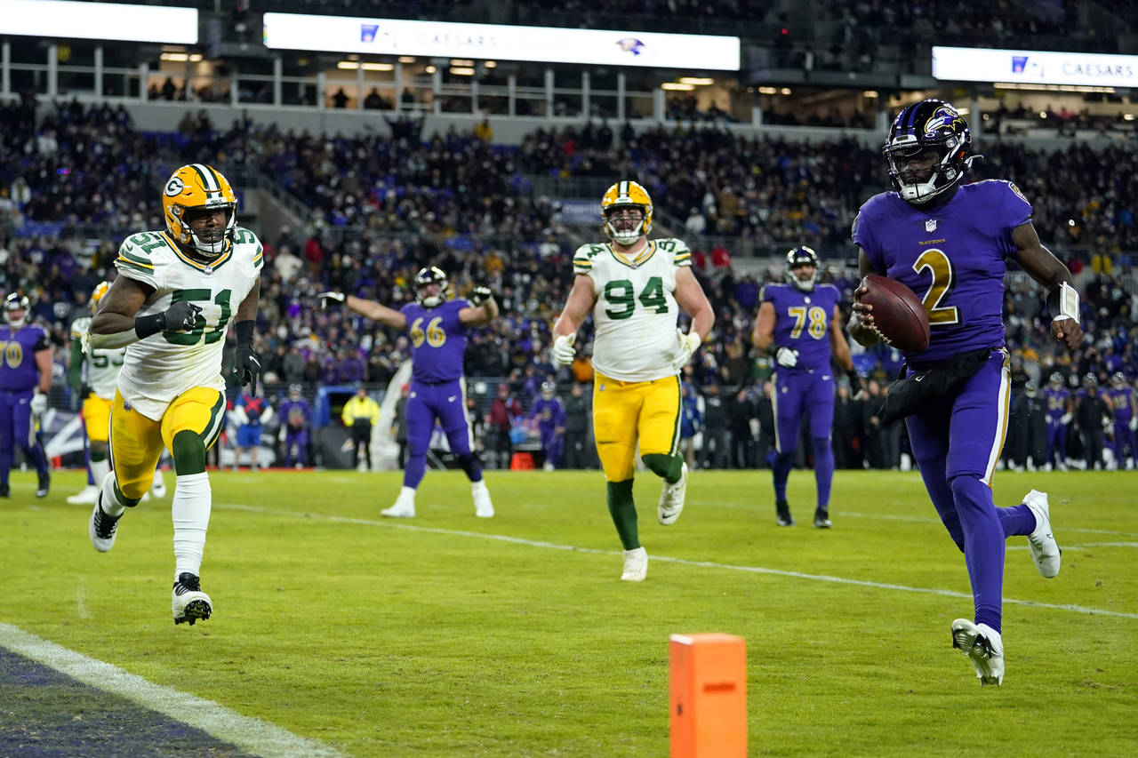 Baltimore Ravens quarterback Tyler Huntley, right, rushes for a touchdown past Green Bay Packers in...