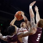 
              Southern California guard Boogie Ellis, center, shoots against Eastern Kentucky guards Russhard Cruickshank, left, and Cooper Robb during the first half of an NCAA college basketball game Tuesday, Dec. 7, 2021, in Los Angeles. (AP Photo/Ringo H.W. Chiu)
            