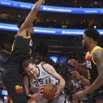 
              San Antonio Spurs center Jakob Poeltl (25) looks for an opening as Utah Jazz center Hassan Whiteside, left, and Rudy Gay (8) defend during the first half of an NBA basketball game on Friday, Dec. 17 2021, in Salt Lake City. (AP Photo/Kim Raff)
            