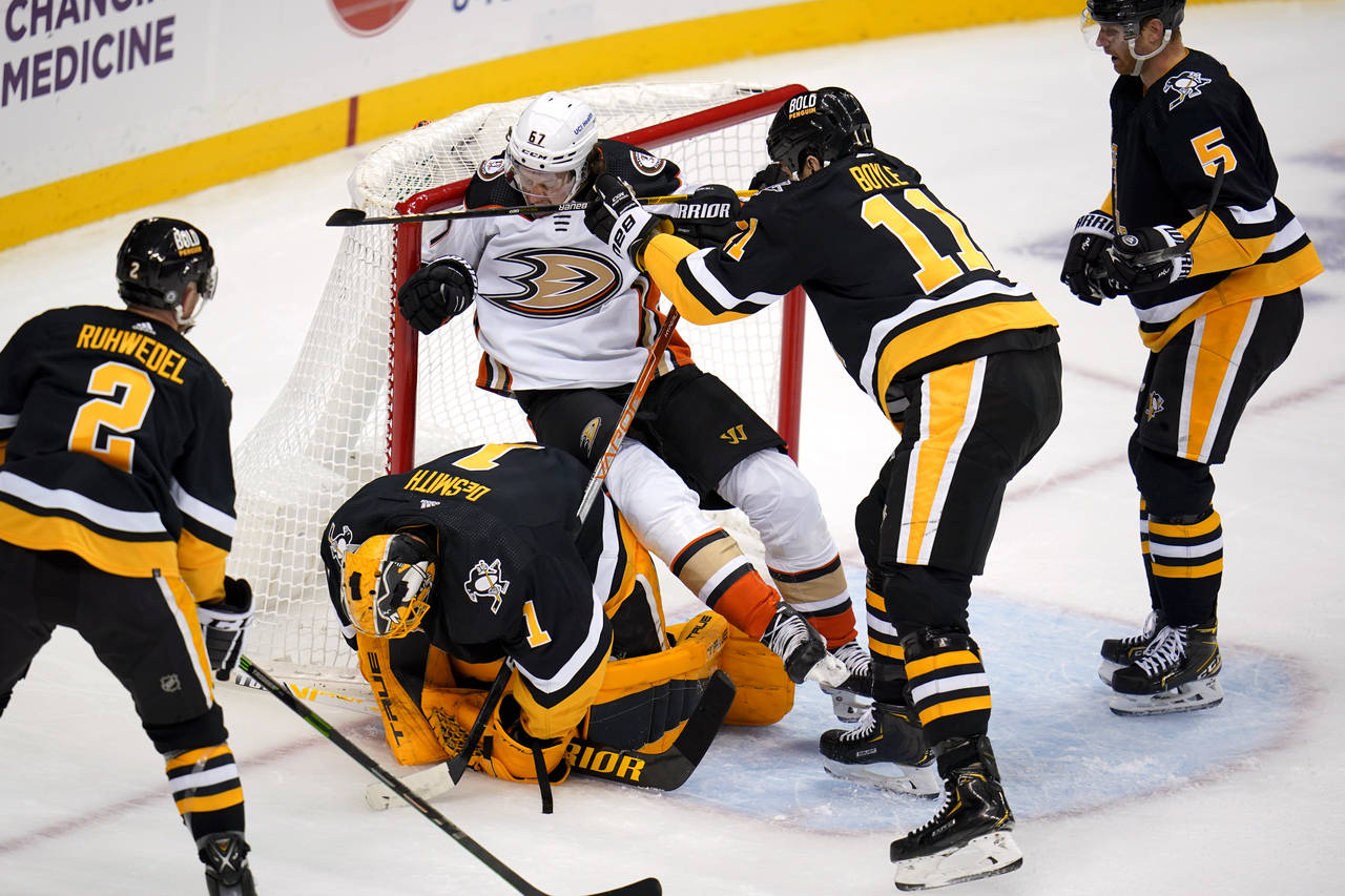 Pittsburgh Penguins goaltender Casey DeSmith (1) covers the puck as Brian Boyle (11) checks Anaheim...