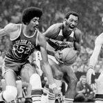 
              FILE - Washington Bullets' Elvin Hayes, center, drives for a basket in the first game of the NBA Championship series at Capital Centre, Landover, Md., May 19, 1975. Golden State Warriors' George Johnson (52) and Rick Barry (24) double teamed Hayes and stopped him from making the shot. (AP Photo, File)
            