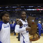 
              Seton Hall's guard Myles Cale (22), carries the trophy after winning an NCAA college basketball game against Rutgers at the Prudential Center, Sunday, Dec. 12, 2021, in Newark, N.J. Seton Hall won 77-63. (AP Photo/Eduardo Munoz Alvarez)
            
