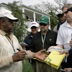 
              FILE - Lee Elder signs autographs for patrons outside the club house at the 2008 Masters golf tournament at the Augusta National Golf Club in Augusta, Ga., Monday, April 7, 2008. Hank Aaron made history with one swing of his bat. A year later and on the other side of Georgia, Elder made history with one swing of his driver. Their deaths in 2021 were mourned beyond the sports world and were reminders of the hate, hardships and obstacles they endured with dignity on their way to breaking records and barriers. (AP Photo/Elise Amendola, File)
            