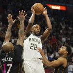 
              Milwaukee Bucks forward Khris Middleton (22) looks to pass under pressure from Miami Heat guard Kyle Lowry (7) and forward P.J. Tucker (17) during the second half of an NBA basketball game, Wednesday, Dec. 8, 2021, in Miami. The Heat defeated the Bucks 113-104. (AP Photo/Marta Lavandier)
            