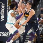
              Denver Nuggets center Nikola Jokic, right, looks to pass the ball as Charlotte Hornets forward Miles Bridges, left, and center Mason Plumlee defend during the first half of an NBA basketball game Thursday, Dec. 23, 2021, in Denver. (AP Photo/David Zalubowski)
            