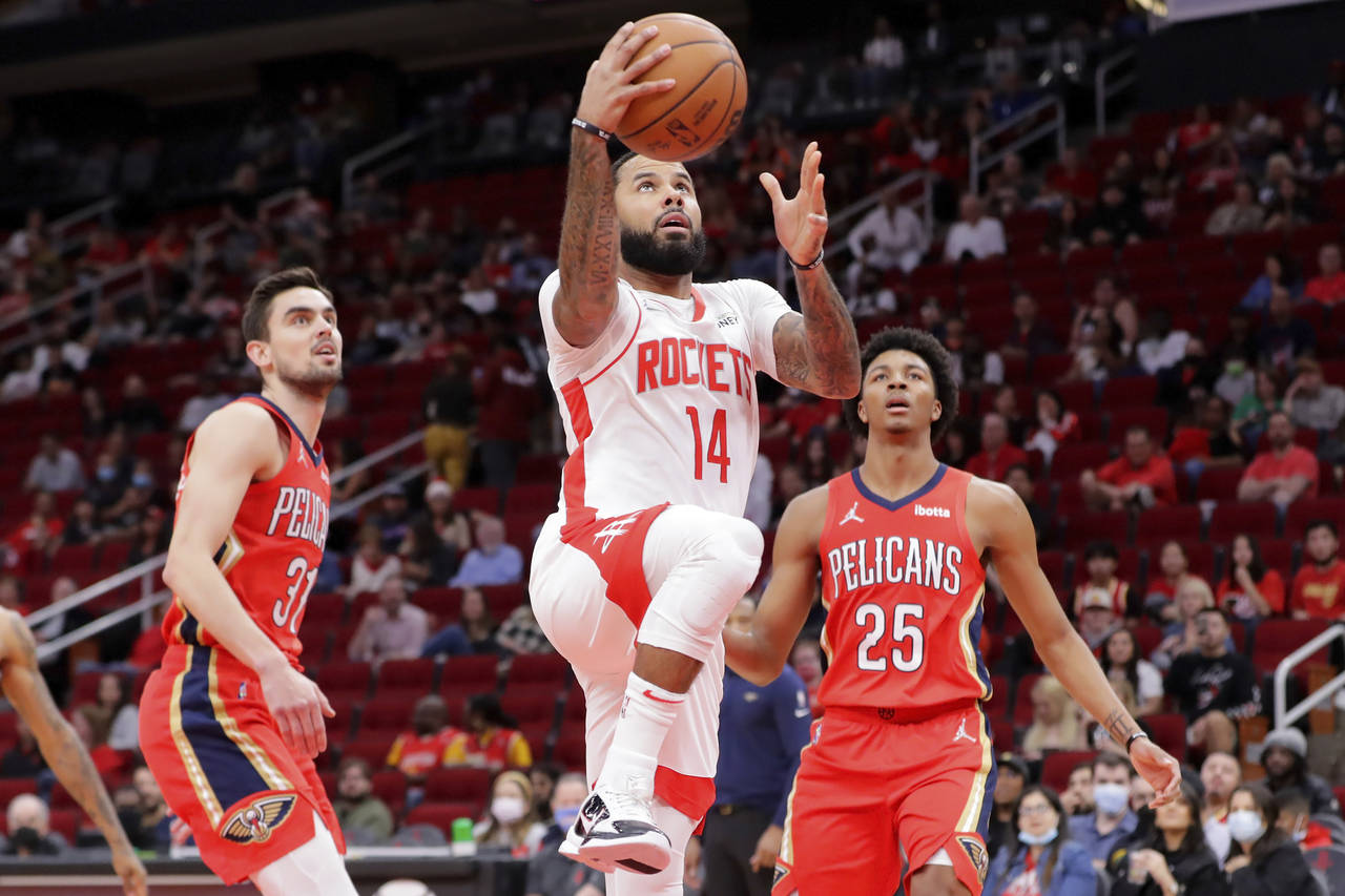 Houston Rockets guard D.J. Augustin (14) shoots between New Orleans Pelicans guards Tomas Satoransk...