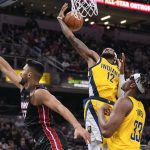 
              Indiana Pacers forward Oshae Brissett (12) pulls in a rebound next to Miami Heat center Omer Yurtseven (77) during the first half of an NBA basketball game in Indianapolis, Friday, Dec. 3, 2021. (AP Photo/AJ Mast)
            