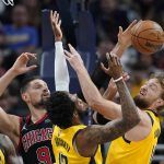 
              Chicago Bulls' Nikola Vucevic (9) battle for a rebound against Indiana Pacers' Oshae Brissett (12) and Domantas Sabonis during the first half of an NBA basketball game, Friday, Dec. 31, 2021, in Indianapolis. (AP Photo/Darron Cummings)
            