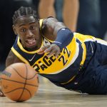 
              Indiana Pacers' Caris LeVert dives for a looser ball during the first half of an NBA basketball game against the Detroit Pistons, Thursday, Dec. 16, 2021, in Indianapolis. (AP Photo/Darron Cummings)
            