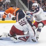 
              Columbus Blue Jackets' goalie Elvis Merzlikins (90) makes the save as Edmonton Oilers' Connor McDavid (97) is checked by Blue Jackets' Zach Werenski (8) during second-period NHL hockey game action in Edmonton, Alberta, Thursday, Dec. 16, 2021. (Jason Franson/The Canadian Press via AP)
            