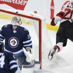 
              Winnipeg Jets goaltender Connor Hellebuyck (37) looks at the puck on the rebound of a shot by New Jersey Devils' Michael McLeod's (20) during the first period of an NHL hockey game Friday, Dec. 3, 2021, in Winnipeg, Manitoba. (John Woods/The Canadian Press via AP)
            