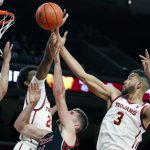 
              Southern California forward Joshua Morgan, left, and forward Isaiah Mobley, right, defend against a shot by Utah forward Riley Battin, center, during the first half of an NCAA college basketball game in Los Angeles, Wednesday, Dec. 1, 2021. (AP Photo/Alex Gallardo)
            