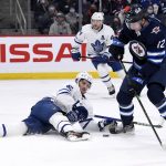 
              Winnipeg Jets' Jansen Harkins (12) and Toronto Maple Leafs' Alexander Kerfoot (15) fight for possession of the puck during the second period of NHL hockey game action in Winnipeg, Manitoba, Sunday, Dec. 5, 2021. (Fred Greenslade/The Canadian Press via AP)
            