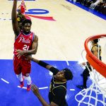 
              Philadelphia 76ers' Joel Embiid, left, shoots over Golden State Warriors' Kevon Looney, right, during the first half of an NBA basketball game, Saturday, Dec. 11, 2021, in Philadelphia. (AP Photo/Chris Szagola)
            