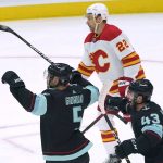 Seattle Kraken defenseman Mark Giordano, left, celebrates with center Colin Blackwell (43) next to Calgary Flames center Trevor Lewis (22) after Giordano scored a goal with an assist from Blackwell during the first period of an NHL hockey game, Thursday, Dec. 30, 2021, in Seattle. (AP Photo/Ted S. Warren)