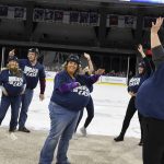 
              Local teachers wave to the crowd while holding piles of money in their shirts on Saturday, December 11, 2021, in the first-ever Dash For Cash between periods at the Sioux Falls Stampede game in Sioux Falls, S.D. (Erin Woodiel/The Argus Leader via AP)
            