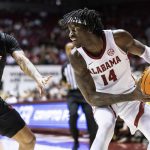 
              Alabama guard Keon Ellis (14) looks inside as Jacksonville State guard Jalen Gibbs (22) trails the play during the first half of an NCAA college basketball game, Saturday, Dec. 18, 2021, in Tuscaloosa, Ala. (AP Photo/Vasha Hunt)
            
