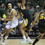 
              Baylor guard Kendall Brown (2) drives past Arkansas-Pine Bluff forward Trey Sampson (23) while looking for an open teammate in the first half of an NCAA college basketball game in Waco, Texas, Saturday, Dec. 4, 2021. (AP Photo/Emil Lippe)
            