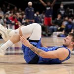 
              Dallas Mavericks guard Luka Doncic reaches for his left leg after taking a spill in the second half of an NBA basketball game against the New Orleans Pelicans in Dallas, Friday, Dec. 3, 2021. (AP Photo/Tony Gutierrez)
            