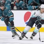 Seattle Kraken left wing Brandon Tanev (13) moves the puck up the ice past San Jose Sharks center Nick Bonino (13) during the second period of an NHL hockey game Tuesday, Dec. 14, 2021, in San Jose, Calif. (AP Photo/Tony Avelar)