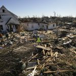 
              Voluteers help Martha Thomas, second left, salvage possessions from her destroyed home, in the aftermath of tornadoes that tore through the region, in Mayfield, Ky., Monday, Dec. 13, 2021. (AP Photo/Gerald Herbert)
            