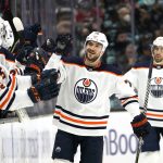 
              Edmonton Oilers' Colton Sceviour is congratulated after scoring against the Seattle Kraken in the second period of an NHL hockey game Saturday, Dec. 18, 2021, in Seattle. (AP Photo/Elaine Thompson)
            