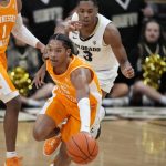 
              Tennessee guard Zakai Zeigler, front, picks up a loose ball as Colorado guard Keeshawn Barthelemy pursues in the first half of an NCAA college basketball game Saturday, Dec. 4, 2021, in Boulder, Colo. (AP Photo/David Zalubowski)
            