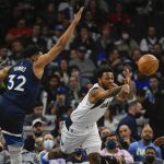 
              Dallas Mavericks guard Sterling Brown, center, passes the ball as Minnesota Timberwolves center Karl-Anthony Towns (32) tries to block it as Timberwolves guard Jaylen Nowell (4) looks on during the first half of an NBA basketball game Sunday, Dec. 19, 2021, in Minneapolis. (AP Photo/Craig Lassig)
            