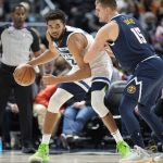 
              Minnesota Timberwolves center Karl-Anthony Towns, left, looks to pass the ball as Denver Nuggets center Nikola Jokic defends in the second half of an NBA basketball game Wednesday, Dec. 15, 2021, in Denver. The Timberwolves won 124-107. (AP Photo/David Zalubowski)
            