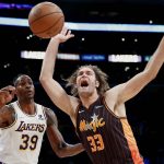 
              Orlando Magic center Robin Lopez (33) struggles to a ball next Los Angeles Lakers center Dwight Howard (39) during the first half of an NBA basketball game in Los Angeles, Sunday, Dec. 12, 2021. (AP Photo/Ringo H.W. Chiu)
            