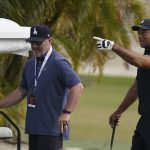 
              Tiger Woods, right, speaks with his trainer Kolby Wayne during a practice session at the Albany Golf Club, on the sidelines of day three of the Hero World Challenge Golf tour, in New Providence, Bahamas, Saturday, Dec. 4, 2021. (AP Photo/Fernando Llano)
            