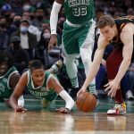 
              Cleveland Cavaliers' Lauri Markkanen, right, moves in to get a loose ball in front of fallen Boston Celtics' Romeo Langford and Robert Williams III (44) during the second quarter of an NBA basketball game Wednesday, Dec. 22, 2021, in Boston. (AP Photo/Winslow Townson)
            