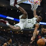 
              Milwaukee Bucks' Thanasis Antetokounmpo (43) hangs from the rim after dunking over Miami Heat's Max Strus during the second half of an NBA basketball game Saturday, Dec. 4, 2021, in Milwaukee. (AP Photo/Morry Gash)
            