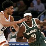 
              Milwaukee Bucks guard Jrue Holiday (21) drives to the basket against New York Knicks guard Quentin Grimes (6) during the second half of an NBA basketball game in New York, Sunday, Dec. 12, 2021. (AP Photo/Noah K. Murray)
            