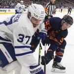 
              Toronto Maple Leafs' Timothy Liljegren (37) and Edmonton Oilers' Ryan Nugent-Hopkins (93) battle for the puck during the second period of an NHL hockey game Tuesday, Dec. 14, 2021 in Edmonton, Alberta  (Jason Franson/The Canadian Press via AP)
            
