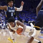 
              Kentucky's Sahvir Wheeler falls after being fouled by Southern University's P.J. Byrd (3) during the first half of an NCAA college basketball game in Lexington, Ky., Tuesday, Dec. 7, 2021. (AP Photo/James Crisp)
            