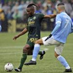 
              Portland Timbers midfielder George Fochive (20) plays the ball ahead of New York City FC midfielder Alfredo Morales (7) during the first half of the MLS Cup soccer match Saturday, Dec. 11, 2021, in Portland, Ore. (AP Photo/Amanda Loman)
            
