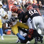 
              Los Angeles Chargers quarterback Justin Herbert is sacked by Cincinnati Bengals' Vonn Bell (24), bottom, and Cameron Sample (96), top, during the second half of an NFL football game, Sunday, Dec. 5, 2021, in Cincinnati. (AP Photo/Jeff Dean)
            